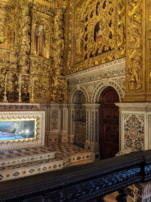 gilded wood flanking a sculpture of Jesus's entombed body